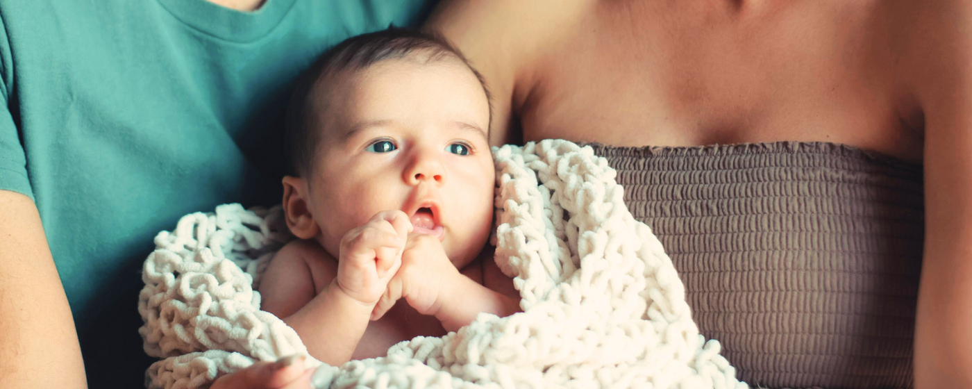 Baby auf dem Schoß seiner Eltern